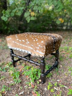 a small bench made out of an old wooden frame with deer hides on it