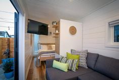 a living room filled with furniture and a flat screen tv mounted to the side of a wall