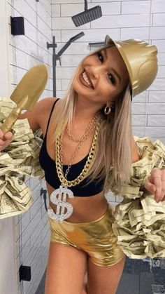 a woman in a gold skirt and hat with stacks of money around her waist, posing for the camera