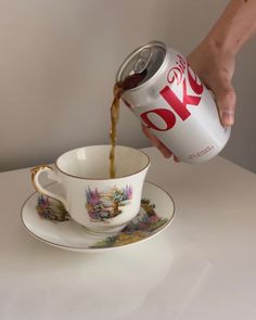 a person pours coffee into a tea cup on a saucer and saucer