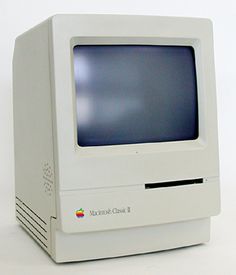 an old apple computer sitting on top of a white table