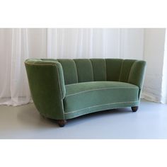 a green couch sitting in front of a window