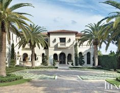 a large white house surrounded by palm trees