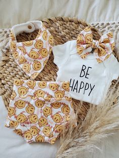 two baby onesuits with smiley faces on them and the words be happy printed on them