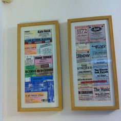 two framed concert tickets are hanging on the wall next to each other in front of a clock