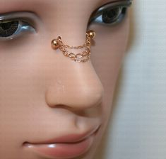 a mannequin's head with a nose chain attached to it