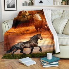 two horses running in the field with sunset behind them on a blanket that is draped over a couch