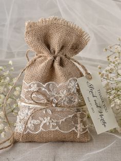 a small bag that is sitting on top of a table next to some white flowers