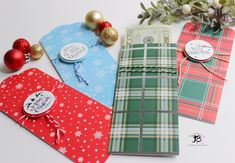 four christmas gift bags with tags on them and ornaments around the edges, all decorated in different colors