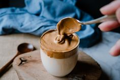 a spoon full of peanut butter on top of a cup