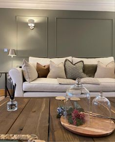 a living room filled with furniture and pillows on top of a wooden table in front of a white couch