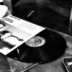 a black and white photo of an album on a record player's turntable