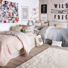 a bedroom with white and gray bedding, rugs and pictures on the wall