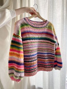 a colorful sweater hanging on a clothes hanger