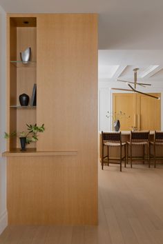 an empty dining room with wooden shelves and chairs