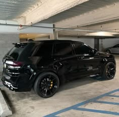 a black suv parked in a parking garage