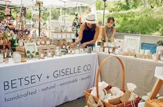 two women at an outdoor flea market selling handcrafted items and goods for sale