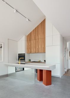 a kitchen with an island counter top and wooden cabinetry on the wall behind it