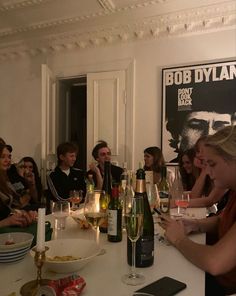 a group of people sitting around a table with wine glasses and food in front of them