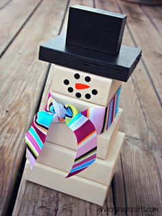 an image of a snowman made out of ties on a wooden table with text overlay