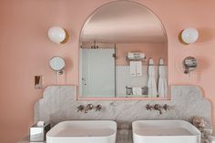 two white sinks sitting under a mirror in a bathroom