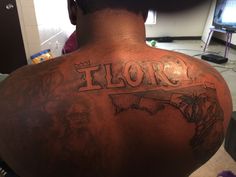 the back of a man's neck with tattoos on it that reads florida and features images of people