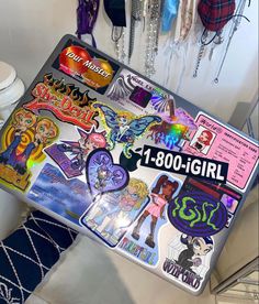 a laptop computer sitting on top of a table covered in stickers