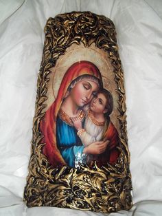 an image of the virgin mary and child jesus on a gold frame with white background