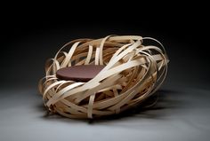 a chair made out of wooden strips with a cushion on the back and seat pad