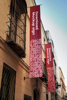 two red banners hanging from the side of a building