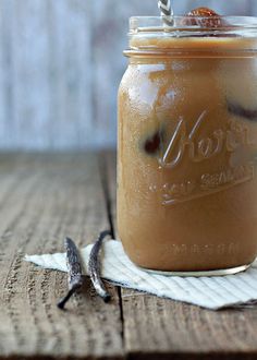 a glass jar filled with liquid sitting on top of a wooden table