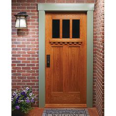 the front door is made of wood and has a welcome mat