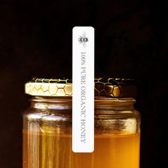 a jar filled with honey sitting on top of a table next to a sticker