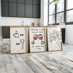 three framed art pieces with wine glasses on them in front of a kitchen counter top