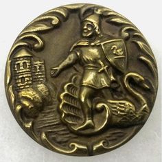 a gold colored button with an image of a man on a boat in the water