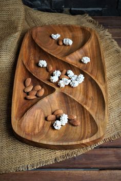 three wooden trays filled with nuts and marshmallows on top of burlap