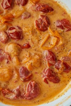 a white bowl filled with meat and cheese covered in gravy on top of a wooden table