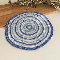 a blue and white crocheted rug sitting on top of a table