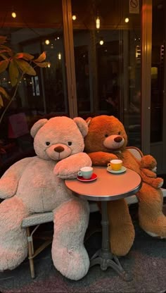 two large teddy bears sitting at a table