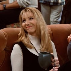 a woman sitting in a chair holding a coffee cup