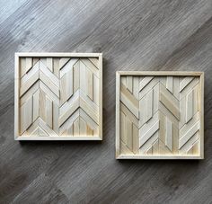 two wooden wall art pieces sitting on top of a wooden floor