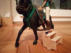 a toy horse and rider on wooden floor