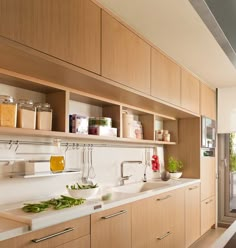 a kitchen filled with lots of wooden cabinets and counter top space next to a window