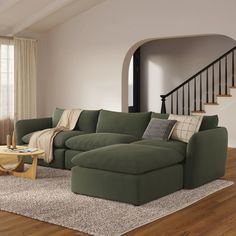 a living room with a large green couch and coffee table in it's center