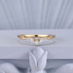 a gold ring with white opal stones on the side and an arrow shaped band