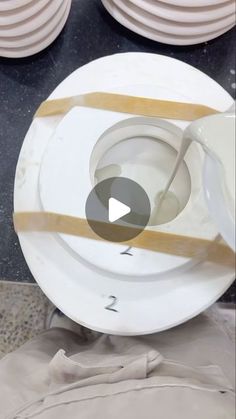 a white plate sitting on top of a table next to plates with gold trimmings