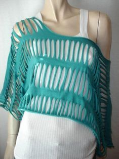 a white mannequin wearing a green top with cutouts on it's shoulders