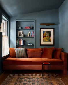 a living room filled with furniture and bookshelves next to a painting on the wall