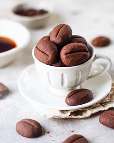 some coffee beans in a white cup on a saucer