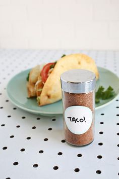 a plate with some food on it next to a glass jar that says taco